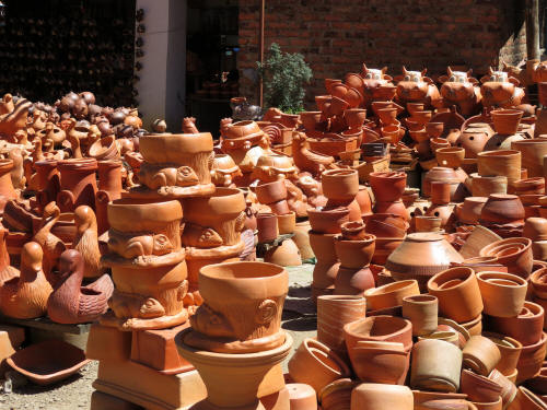 THINGS TO DO AT RAQUIRA POTTERY, COLOMBIA: In the production shops, pottery is being displayed in a chaotic random fashion.